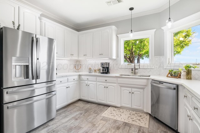 1918 Arroya Rd, Dalhart, TX 79022 - kitchen with white cabinetry, appliances with stainless steel finishes, light countertops, and a sink