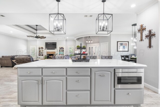 1918 Arroya Rd, Dalhart, TX 79022 - kitchen featuring a center island, open floor plan, crown molding, and gray cabinetry
