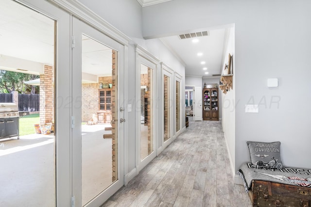 1918 Arroya Rd, Dalhart, TX 79022 - hall with light wood-type flooring, visible vents, crown molding, and french doors