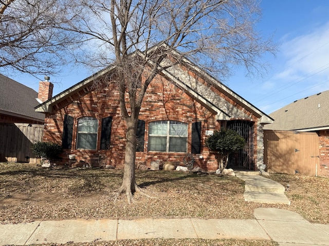 view of front of house featuring fence and brick siding