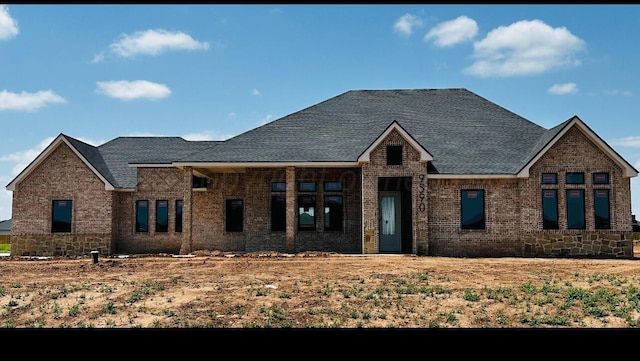 view of front of property with brick siding and a shingled roof