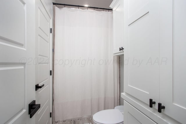 bathroom featuring toilet and a shower with shower curtain