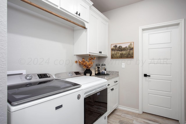 laundry area featuring separate washer and dryer and cabinets