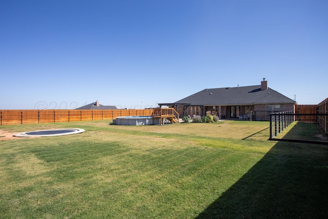 view of yard featuring a fenced in pool and a trampoline