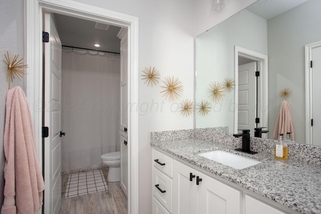 bathroom with toilet, vanity, and hardwood / wood-style flooring