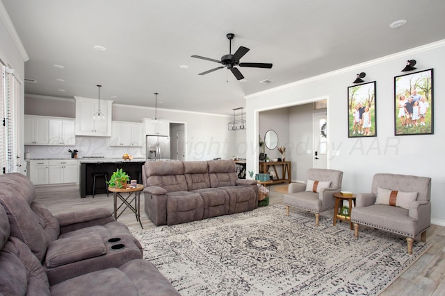 living room featuring ceiling fan, light wood-type flooring, and crown molding