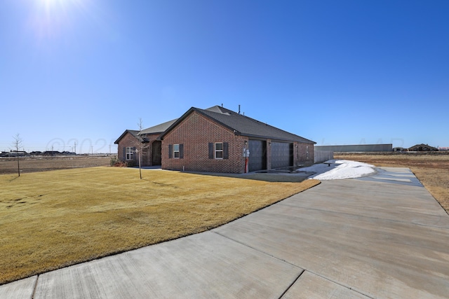 rear view of house with a lawn and a garage