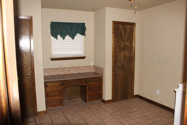 interior space featuring ceiling fan, baseboards, and tile patterned floors