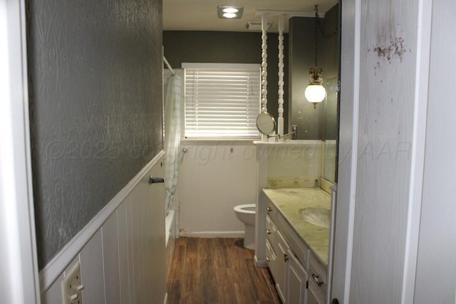 bathroom featuring visible vents, toilet, shower / bath combo with shower curtain, vanity, and wood finished floors