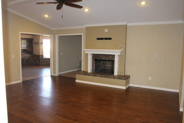 unfurnished living room featuring lofted ceiling, a fireplace, ornamental molding, and wood finished floors