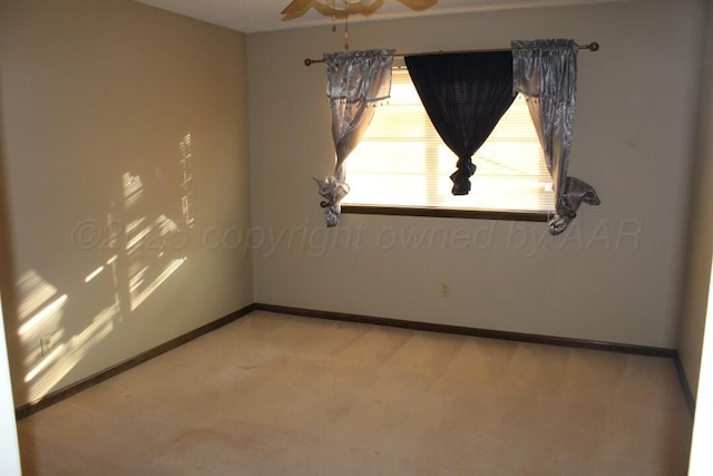 unfurnished room with ceiling fan, light carpet, and baseboards