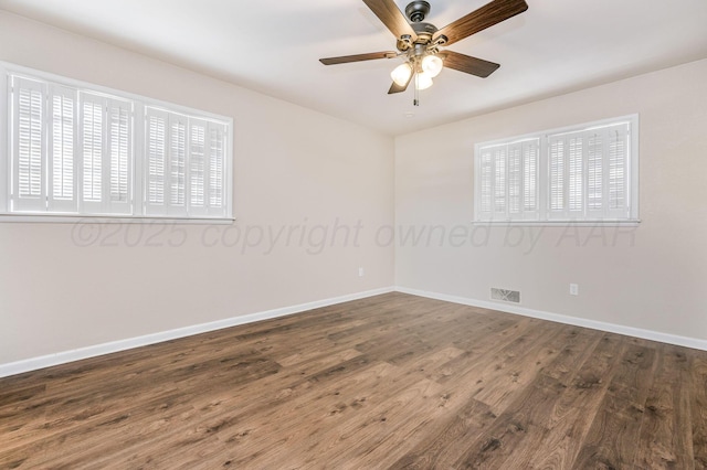 unfurnished room featuring baseboards, visible vents, wood finished floors, and ceiling fan