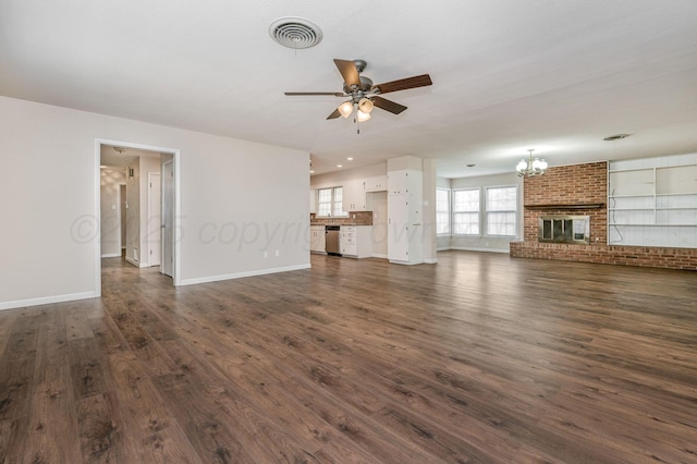 unfurnished living room with dark wood finished floors, ceiling fan with notable chandelier, baseboards, and visible vents