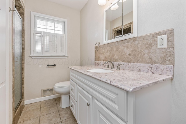 bathroom with tile patterned flooring, vanity, toilet, a shower stall, and visible vents