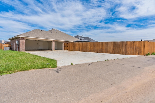 7912 Pensacola Ave, Amarillo, TX 79118 - view of side of property featuring fence, concrete driveway, a garage, and brick siding