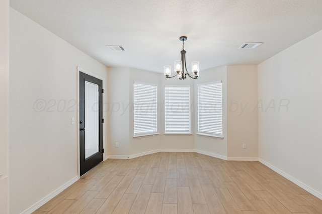7912 Pensacola Ave, Amarillo, TX 79118 - empty room with visible vents, baseboards, a chandelier, and light wood-type flooring