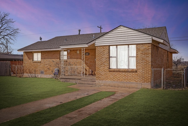 exterior space with a yard, brick siding, and fence