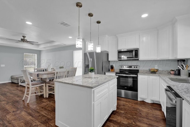 2913 Wichita Ave, Amarillo, TX 79107 - kitchen with stainless steel appliances, dark wood-style floors, recessed lighting, a kitchen island, and white cabinets