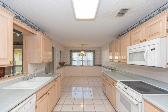 kitchen featuring white appliances, a sink, light brown cabinets, light tile patterned flooring, and light countertops