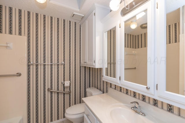 bathroom featuring toilet, vanity, a shower, and wallpapered walls