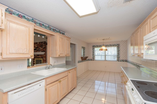 kitchen with white appliances, wallpapered walls, light tile patterned floors, light brown cabinetry, and a sink