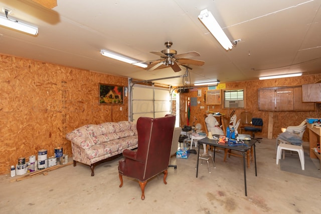 misc room with unfinished concrete flooring, wooden walls, a garage, and cooling unit