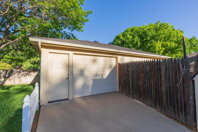 view of outbuilding with fence and a garage