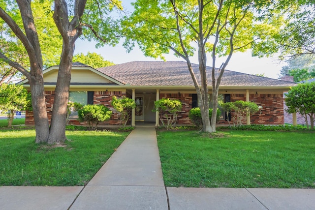 single story home featuring a front yard and brick siding