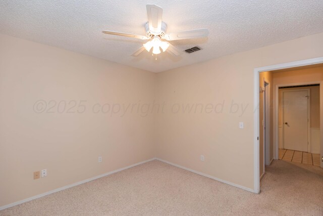 unfurnished bedroom featuring light colored carpet, a textured ceiling, ceiling fan, and baseboards
