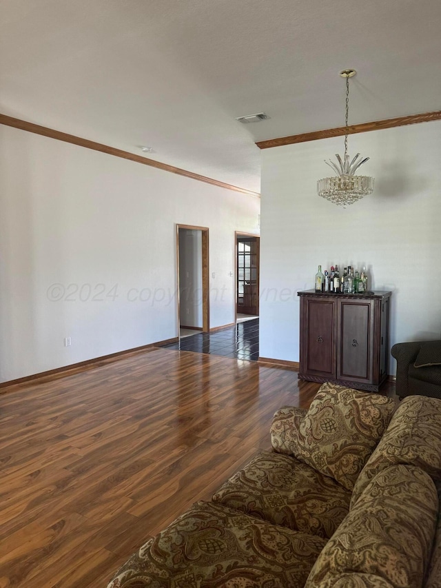 living room featuring crown molding, dark hardwood / wood-style flooring, and a chandelier