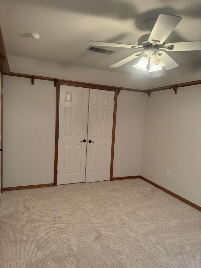 unfurnished bedroom with ceiling fan, a closet, and light carpet