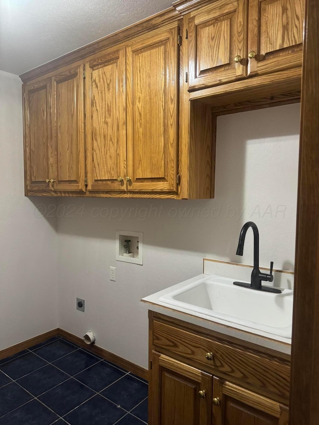 clothes washing area with cabinets, sink, washer hookup, dark tile patterned floors, and hookup for an electric dryer