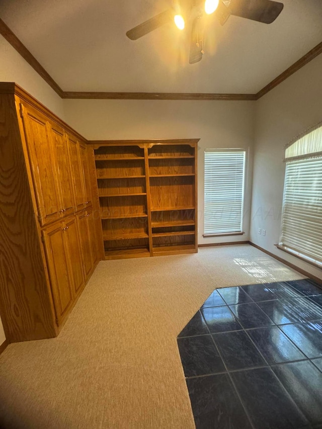 interior space featuring carpet floors, ceiling fan, and crown molding