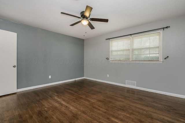 empty room with baseboards, visible vents, ceiling fan, and wood finished floors