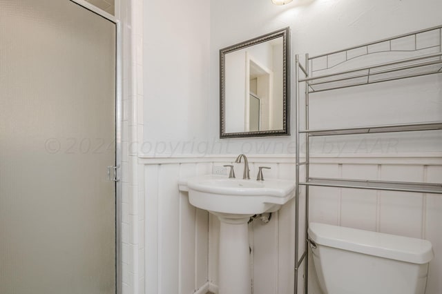 bathroom featuring a stall shower and toilet