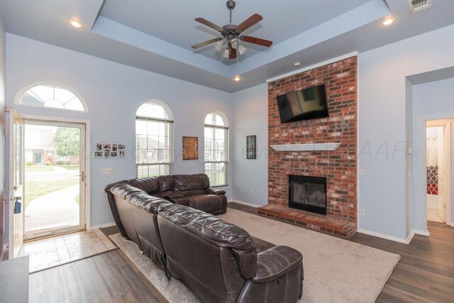 6205 S Bonham St, Amarillo, TX 79118 - living area featuring wood finished floors, a ceiling fan, a brick fireplace, a raised ceiling, and recessed lighting