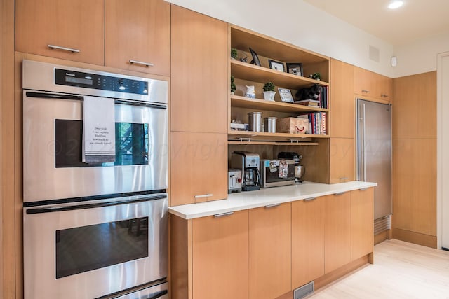 kitchen featuring light wood-type flooring and stainless steel double oven