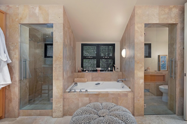 bathroom with toilet, tile walls, vaulted ceiling, and separate shower and tub