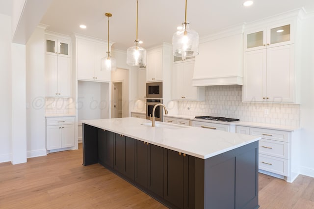 kitchen featuring decorative backsplash, light wood-style floors, white cabinetry, a sink, and appliances with stainless steel finishes