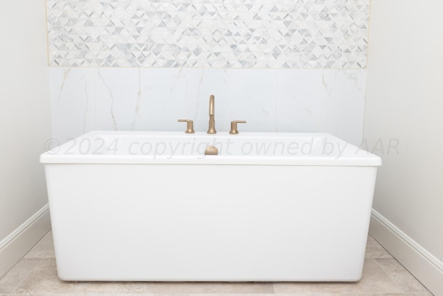 bathroom featuring baseboards and a soaking tub