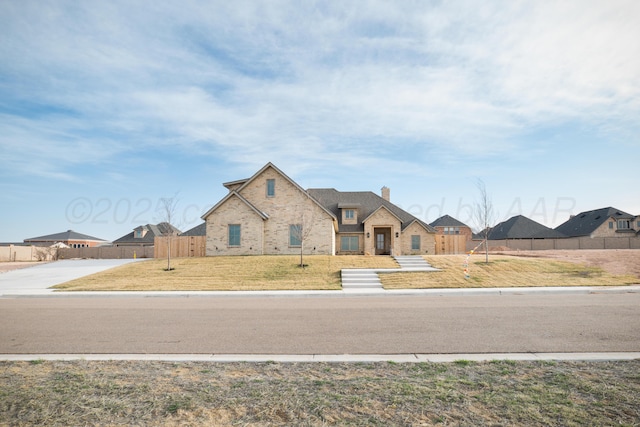 view of front of property with fence, a residential view, a chimney, and brick siding