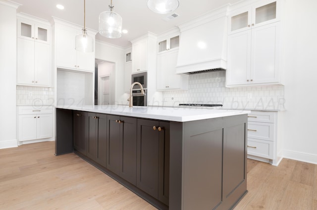 kitchen featuring light countertops, light wood-style flooring, appliances with stainless steel finishes, and white cabinets