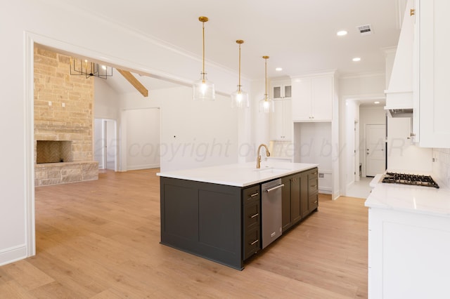 kitchen with a sink, appliances with stainless steel finishes, white cabinets, and backsplash