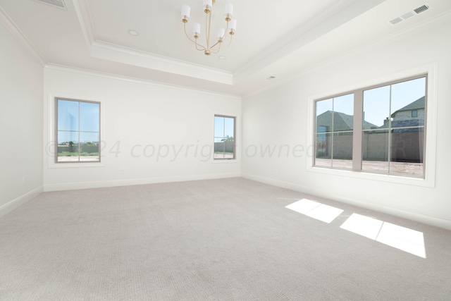 empty room featuring crown molding, carpet floors, a chandelier, a tray ceiling, and visible vents