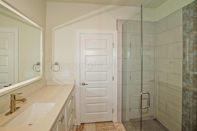 bathroom featuring hardwood / wood-style floors, vanity, and an enclosed shower
