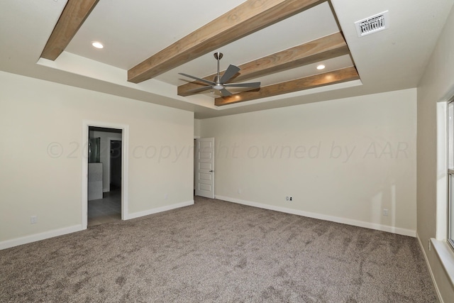 carpeted spare room featuring a tray ceiling and ceiling fan