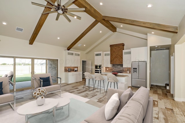 living room featuring ceiling fan, beamed ceiling, high vaulted ceiling, and light wood-type flooring