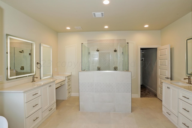 bathroom featuring tile patterned flooring, vanity, and tiled shower