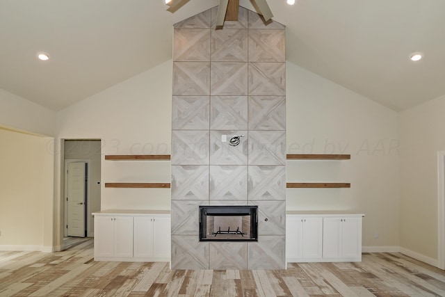 unfurnished living room featuring a fireplace, light hardwood / wood-style flooring, and vaulted ceiling