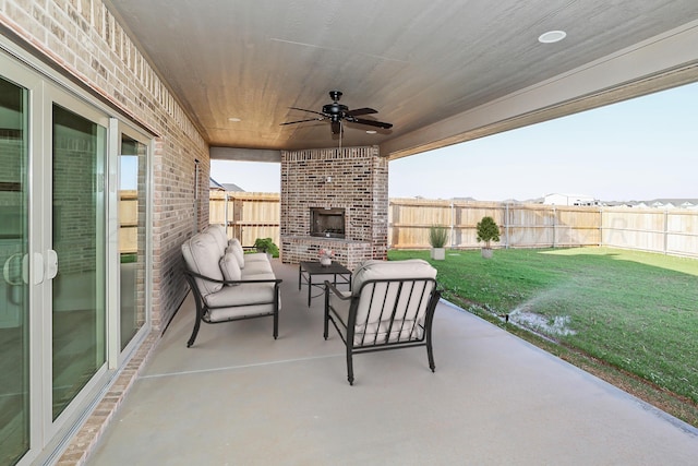 view of patio / terrace with an outdoor living space with a fireplace and ceiling fan